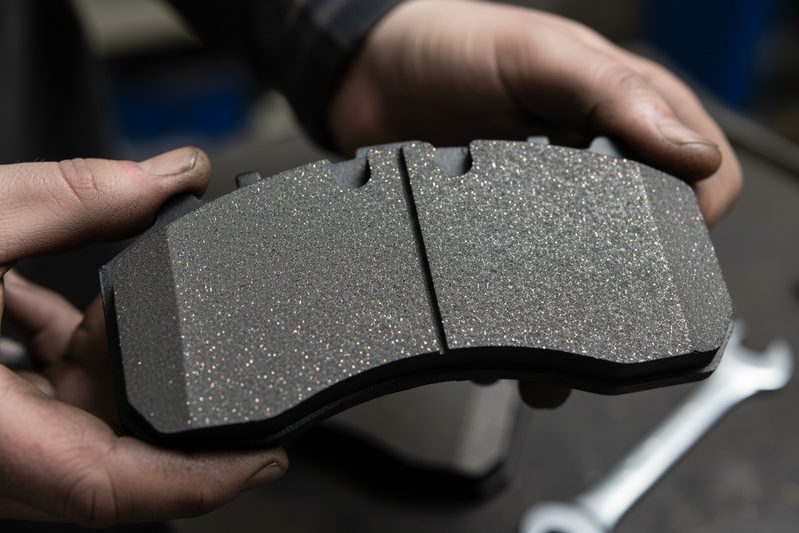 Close-up of ceramic brake pad material showing fine copper fibers and composite structure for consistent performance.