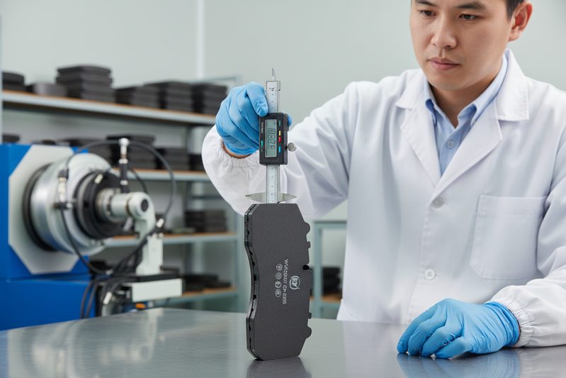 BAIYUN Brake quality control technician inspecting a batch of quiet, low-NVH brake pads in the factory.