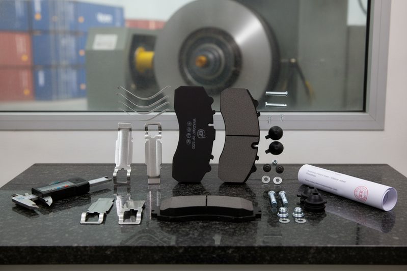 BAIYUN brake pad being inspected for ECE R90 homologation in a testing laboratory, showing thickness measurement and approval report
