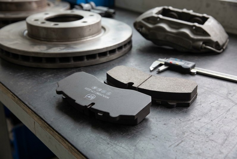 Commercial vehicle brake pad uneven wear inspection with damaged rotor and caliper