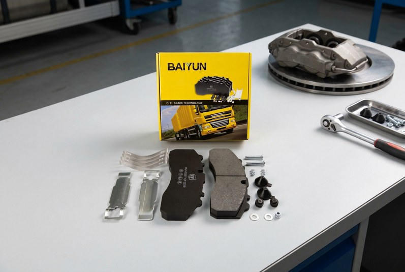 BAIYUN cp2218 commercial vehicle brake pad set inspected with digital caliper next to truck caliper and rotor